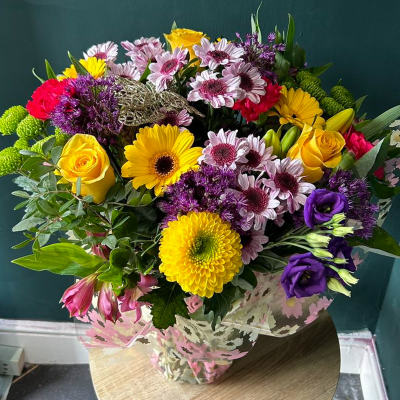 Vibrant Cheer - A lively arrangement bursting with bright and cheerful flowers, including gerberas and roses. Perfect for sending a message of joy and celebration.