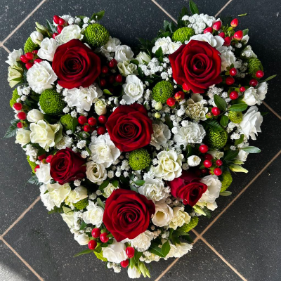 Red Rose Heart Tribute - A stunning heart-shaped arrangement with red roses, white carnations, and green accents. Ideal for conveying deep love and sympathy at funerals.