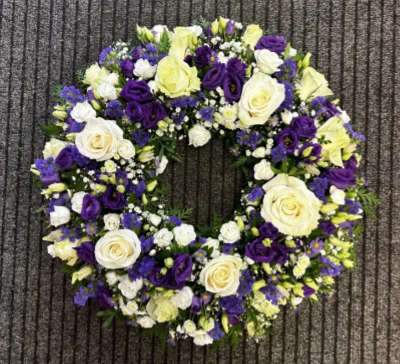 Treasured Memories - Our Treasured Memories wreath is made is a simple colour palette of whites and purples. 
Featuring white roses and gypsophila and rich purple lisianthus.

Item shown is the medium