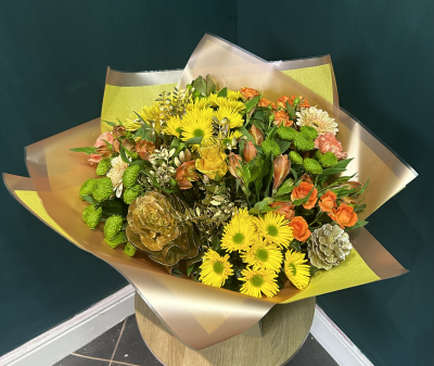 Fireside Glow - Fireside Glow brings all the warmth and sparkle of the season.
Featuring a variety of yellow and orange toned blooms with a selection of them hand glittered, gold foliage woven through gives this hand tied bouquet its name. 

Made live on TikTok Fireside Glow is part of our alternative Christmas range.

Item featured is the medium