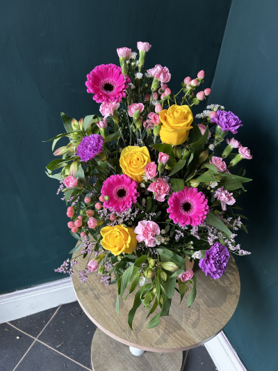 Bright Betty - Bold and beautiful the Bright Betty is a compact front facing arrangement bursting with bright blooms. 

The colour palette is all about the bright and bold colours. Made using seasonal blooms and always including roses. 

Item shown is medium